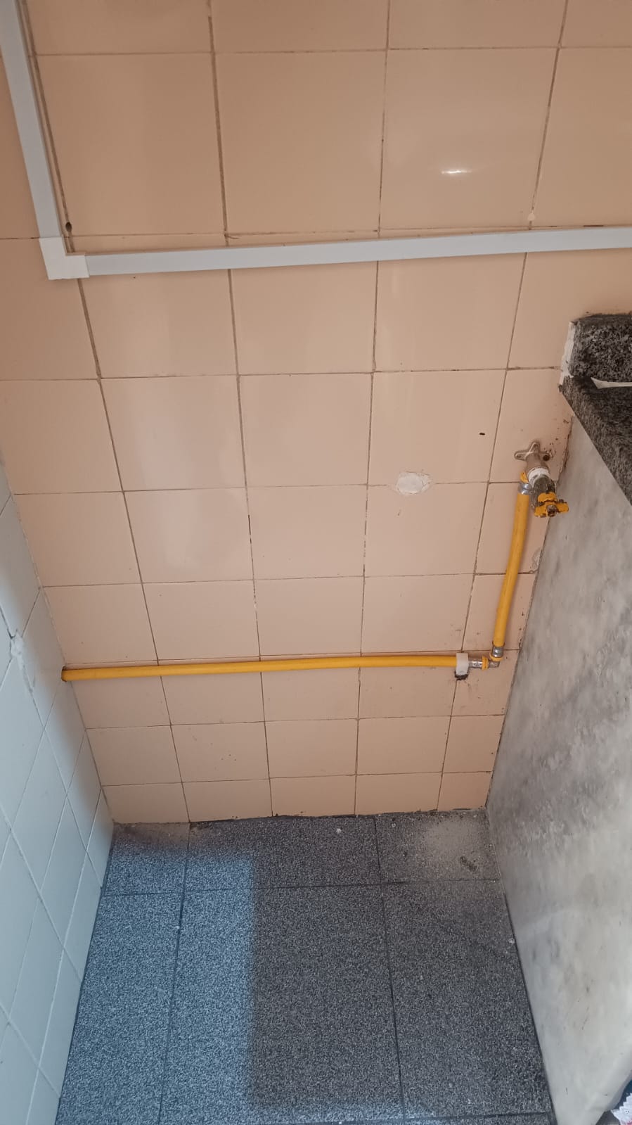 Tubulação de gás amarela instalada em banheiro com azulejos